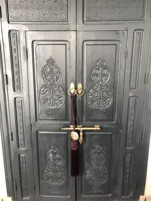 a gray door with a red umbrella on it at Riad Dowaya in Marrakech