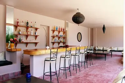 a bar with a bunch of stools in a room at La Maison Des Oliviers in Marrakech