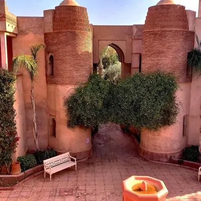 an entrance to a building with an arch and a courtyard at La Maison Des Oliviers in Marrakech