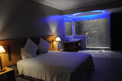 a bedroom with a bed and a bathroom with a sink at La Maison Des Oliviers in Marrakech