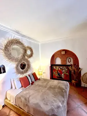a bedroom with a large bed and a mirror at Riad Lauriers Blancs in Marrakech