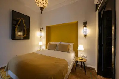 a bedroom with a bed and two lamps and a mirror at Riad Dar Beldia and Spa in Marrakech