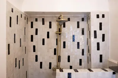 a shower in a bathroom with a tiled wall at Riad Dar Beldia and Spa in Marrakech