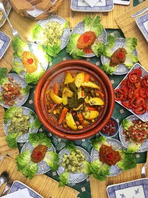 a bowl of food on a table with plates of food at Riad Al Mamoune in Marrakech