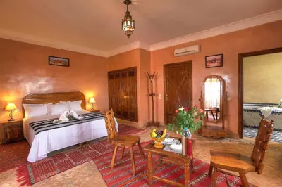 a bedroom with a bed and a table and chairs at Villa Dar Mya Palmiers in Marrakech