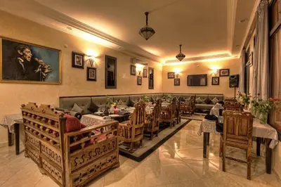 a restaurant with tables and chairs in a room at Villa Dar Mya Palmiers in Marrakech