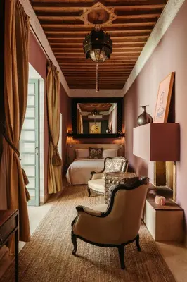 a bedroom with a bed and a couch and a chair at Ryad Dyor in Marrakech