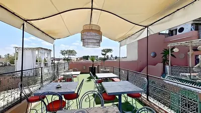 a patio with tables and chairs on a balcony at Riad El Grably in Marrakech