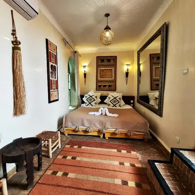 a bedroom with a bed with a large mirror at Riad El Grably in Marrakech