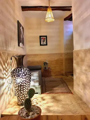 a living room with a couch and a vase on a table at Riad Dar Zouar & Spa in Marrakech