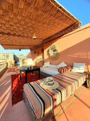 a bed on a patio with a table on a roof at Riad Dar Zouar & Spa in Marrakech