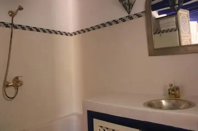a bathroom with a sink and a mirror and a tub at Riad Dar Nael in Marrakech