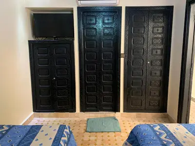 two doors in a room with a bed and a television at Riad jmiaa in Marrakech