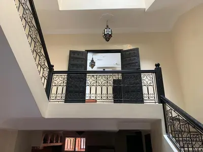 a staircase with black and white railings and a mirror at Riad jmiaa in Marrakech