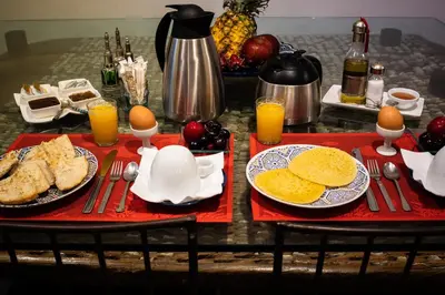 a table topped with plates of eggs and toast at Riad Azcona in Marrakech