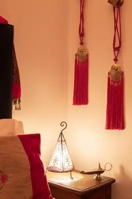 a bedroom with red tassels hanging on the wall at Riad Azcona in Marrakech