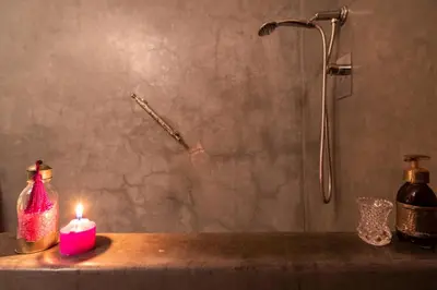 a candle on a counter in a bathroom with a shower at Riad Azcona in Marrakech