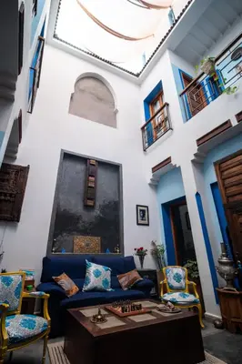 a living room with a blue couch and chairs at Riad Azcona in Marrakech