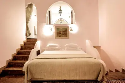 a bedroom with a bed and stairs with a mirror at Marrakech Riads, Angsana Heritage Collection in Marrakech