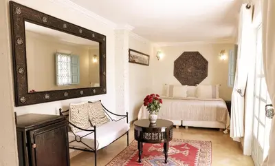 a bedroom with a bed and a mirror and a table at Marrakech Riads, Angsana Heritage Collection in Marrakech