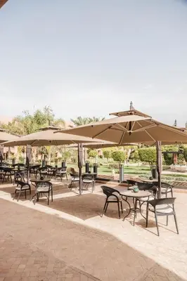 a group of tables and chairs with umbrellas at Kenzi Menara Palace & Resort in Marrakech