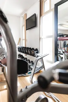 a gym with a row of weights and a tv at Kenzi Menara Palace & Resort in Marrakech