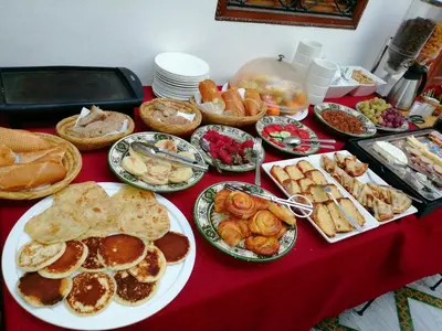 a table with plates of food on a red table at Riad petit Karmela in Marrakech