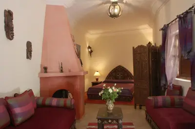 a living room with a bed and a couch and a fireplace at Riad petit Karmela in Marrakech
