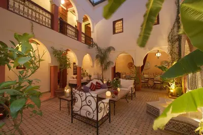 a living room with tables and chairs in a building at Riad petit Karmela in Marrakech