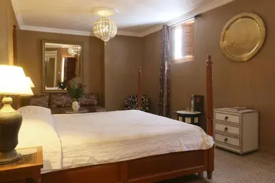 a bedroom with a large bed and a mirror at Riad Karmela in Marrakech