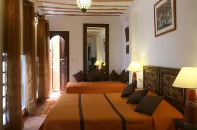 a bedroom with two beds and a couch at Riad Karmela in Marrakech