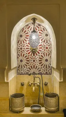 a bathroom sink with two baskets and a faucet at Hotel Islane Médina in Marrakech