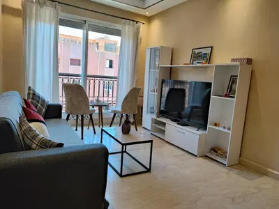 a living room with a couch and a television at Bright Apt in the Heart of Marrakech-Walk Everywhere in Marrakech