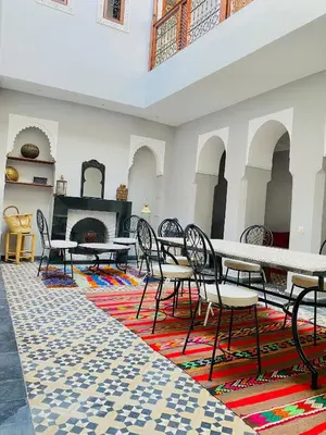 a room with tables and chairs and a fireplace at RIAD GALIYA in Marrakech