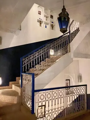 a staircase in a building with a blue railing at Riad Sheba in Marrakech