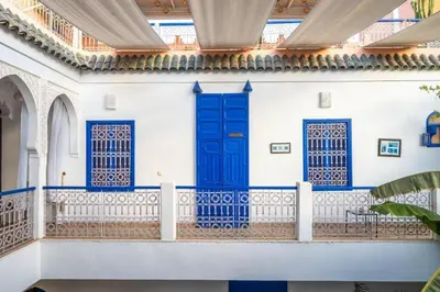 a white building with blue doors and a balcony at Riad Sheba in Marrakech