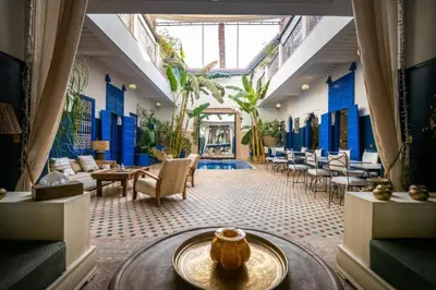 a large room with blue walls and tables and chairs at Riad Sheba in Marrakech