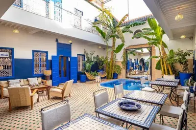 a patio with tables and chairs and a pool at Riad Sheba in Marrakech