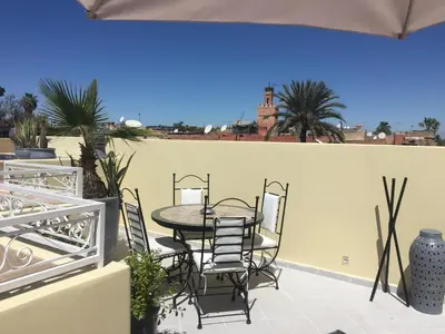 a patio with a table and chairs on a balcony at Riad Nafis in Marrakech