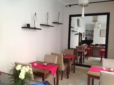 a dining room with tables and chairs and a mirror at Riad Nafis in Marrakech