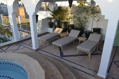 a patio with chairs and a swimming pool at Riad Catalina in Marrakech