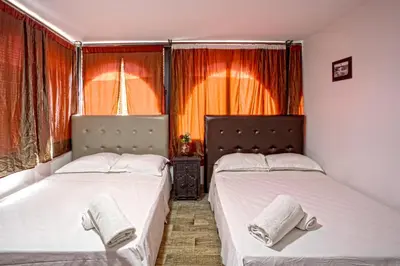 two beds sitting next to each other in a bedroom at Hotel Agnaoue in Marrakech
