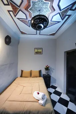a bedroom with a bed with a ceiling with a star at Hotel Agnaoue in Marrakech
