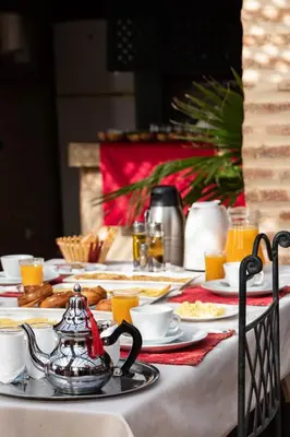 a table with a tea kettle and plates of food at Equity Point Marrakech in Marrakech