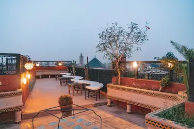 a rooftop patio with tables and chairs and lights at Equity Point Marrakech in Marrakech