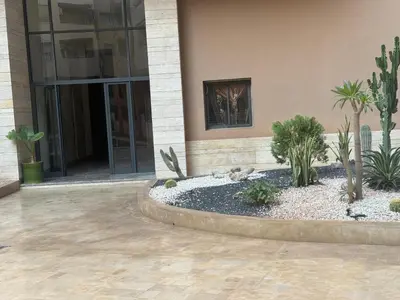 a building with a courtyard with plants in front of it at Appart Kech Menera in Marrakech