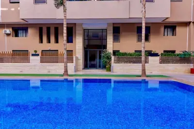a swimming pool in front of a building at Appart Kech Menera in Marrakech