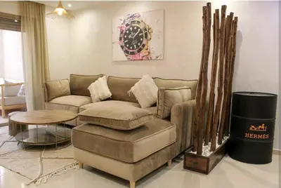 a living room with a couch and a table at COSY APPART avec 2 piscines, 2 CH, 2 SDB Marrakech in Marrakech