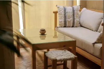 a living room with a table and a couch at COSY APPART avec 2 piscines, 2 CH, 2 SDB Marrakech in Marrakech