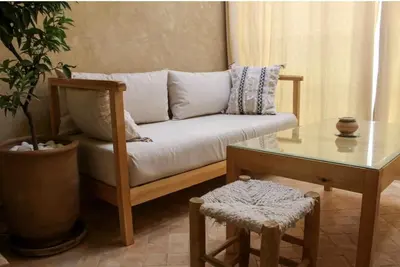a living room with a couch and a table at COSY APPART avec 2 piscines, 2 CH, 2 SDB Marrakech in Marrakech